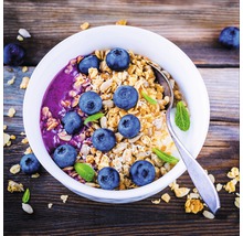 Muesli avec des myrtilles et de la menthe dans un bol avec une cuillère