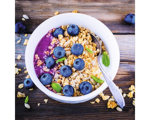 Muesli avec des myrtilles et de la menthe dans un bol avec une cuillère