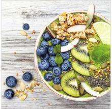 Gros plan d''un bol de smoothie, garni de myrtilles, de kiwi, de noix de coco, de citron vert et de muesli.