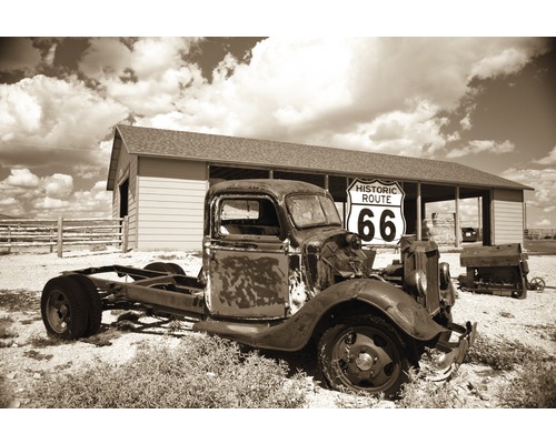 Papier peint panoramique intissé 18925 Rosty Truck 7 pces 350 x 260 cm Un vieux camion rouillé avec un panneau Route 66 devant un bâtiment.
