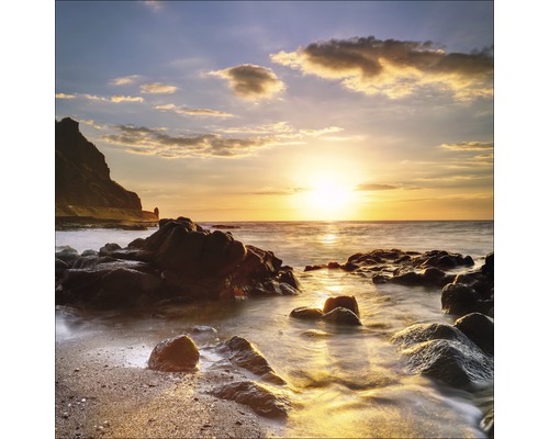 Coucher de soleil sur une côte rocheuse avec des vagues douces