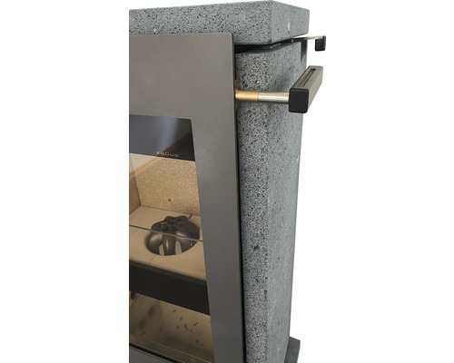 Detailansicht eines Kaminofens mit Steinverkleidung und Türgriff