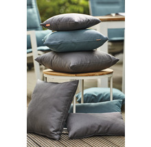 Coussins gris et bleus variés sur une table et un plancher en bois