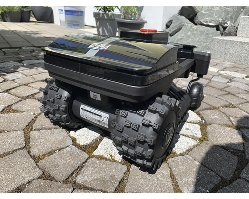 Schwarzer Rasenmähroboter auf Pflastersteinen