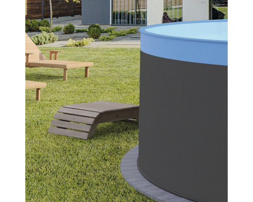 Vue de jardin avec piscine ronde et chaises longues en bois sur pelouse