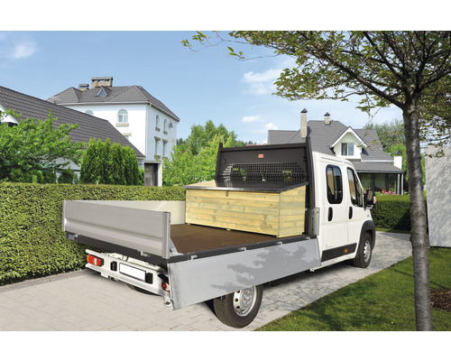 Ein Pritschenwagen mit einer montierten Holzkiste vor einem Wohnhaus.