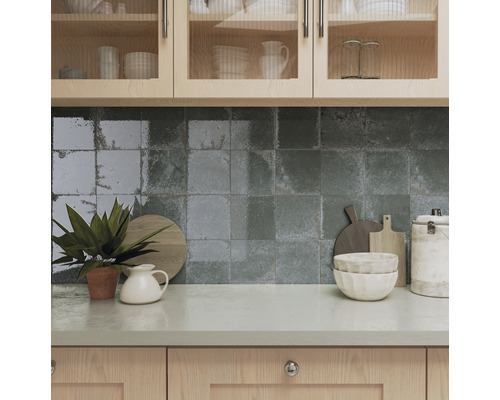 Küchenszene mit Spülbecken, Fliesenwand und Küchenutensilien