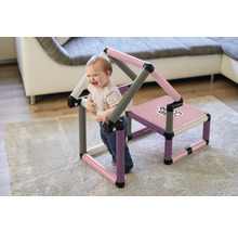 Un jeune enfant joue avec une maison de jeu et une chaise Go-O-Done sur un tapis