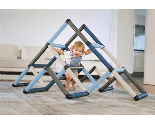 Kleinkind spielt mit einem Indoor-Klettergerüst in einem Wohnzimmer