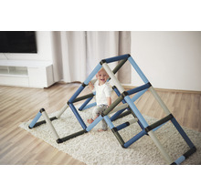 Jeune enfant escalade une structure d''escalade colorée dans un salon.