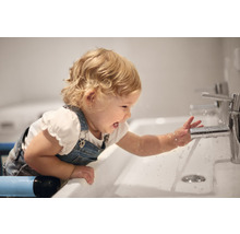 Enfant joue avec de l''eau dans une vasque avec robinet