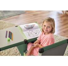 Fille à un bureau d''enfant avec des crayons de couleur et un livre de coloriage