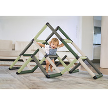 Un jeune enfant grimpe sur une structure d''escalade triangulaire à l''intérieur.