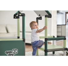 Un jeune enfant grimpe sur une structure d''escalade QUADRO à l''intérieur.