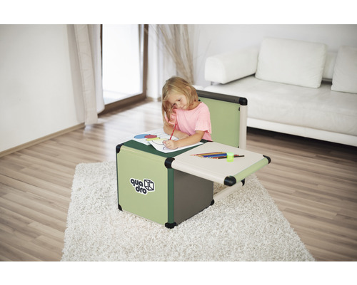 Mädchen malt am Kindertisch aus Kunststoff, im Hintergrund ein Sofa.