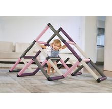 Un jeune enfant joue avec une structure d''escalade faite de tubes en plastique à l''intérieur.