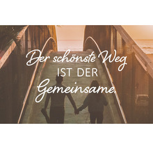 Paar geht gemeinsam über Brücke mit dem Schriftzug: Der schönste Weg ist der Gemeinsame