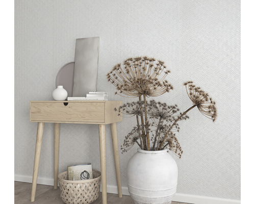 Dekorative Szene mit Holztisch, weißer Vase mit Blumen und geometrischer Tapete