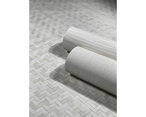 Deux rouleaux de papier peint sur un fond à motif à chevrons