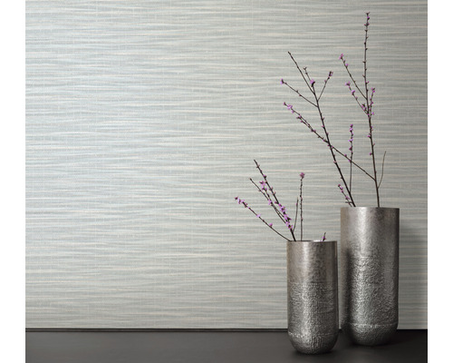 Wohnraum mit gemusterter Tapete und zwei silberfarbenen Vasen mit Zweigen