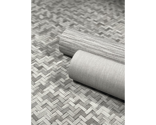 Zwei gerollte Teppiche auf einem Bodenbelag im Fischgrätmuster