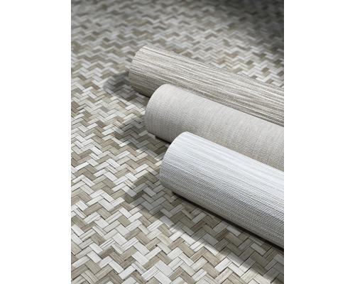 Drei Tapetenrollen auf geflochtenem Untergrund