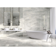 Salle de bain lumineuse avec baignoire, double vasque et carrelage mural et au sol imitation marbre.