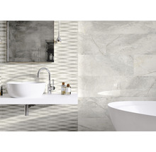 Salle de bain avec lavabo, baignoire et carreaux muraux aspect marbre