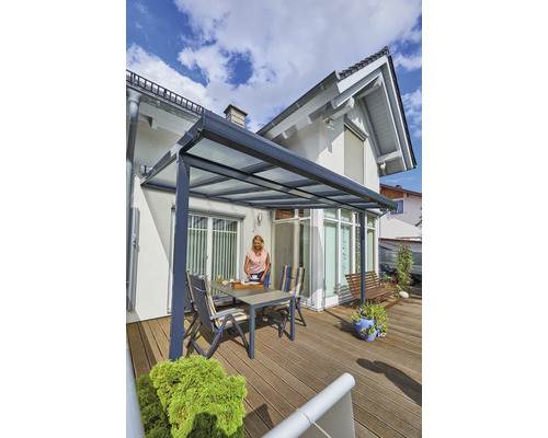 Terrasse avec toit de terrasse, table et chaises devant une maison