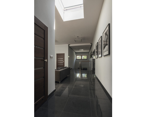 Heller Flur mit Dachfenster, dunklen Türen und Fliesenboden