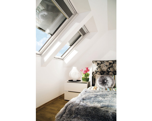 Schlafzimmer mit Dachfenstern, Bett und Nachttisch für Dachgeschosswohnung