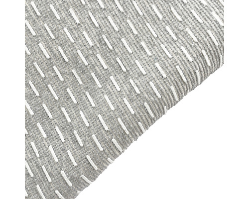 Vue détaillée d''un tapis gris avec des surpiqûres décoratives blanches