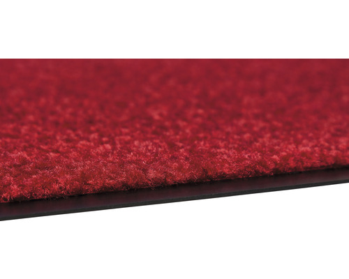 Vue détaillée d''une dalle de moquette rouge avec un dessous noir.