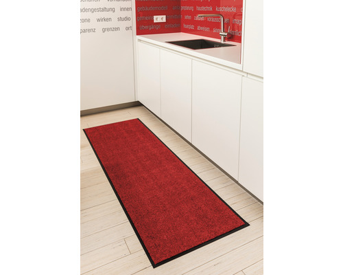 Tapis rouge avec bordure noire dans une cuisine.