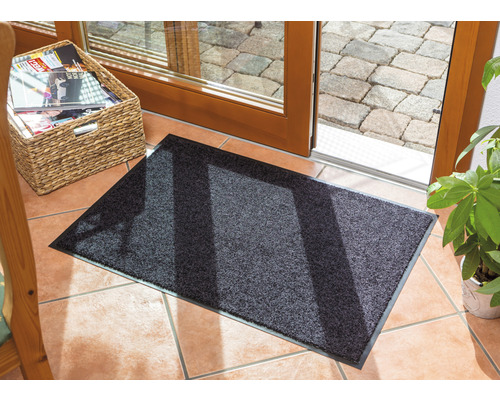 Tapis de sol devant une porte de terrasse avec panier à magazines et plante en pot