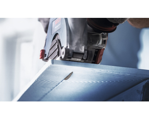 Eine Mauernutfräse schneidet in Mauerwerk.