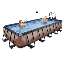 Piscine rectangulaire avec habillage en bois, avec échelle et deux personnes dans l''eau.