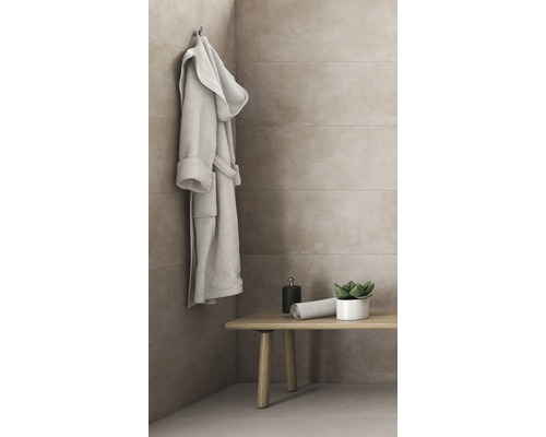 Badezimmer mit Bademantel, Bank, Handtuch und Pflanze vor gefliester Wand