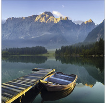 Lac avec jetée en bois, bateau et panorama montagneux