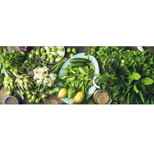 Légumes frais et herbes aromatiques sur une table, y compris artichauts, choux de Bruxelles, concombres et épinards