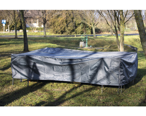 Mobilier de jardin avec housse de protection grise sur une pelouse