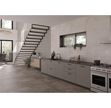 Pièce lumineuse avec escalier, kitchenette, sol carrelé et mur carrelé