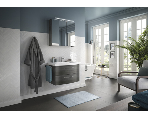 Badezimmer mit Waschtisch, Spiegelschrank, Badewanne, Sessel und dekorativen Elementen für eine stilvolle Einrichtung