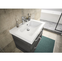 Badezimmerwaschtisch mit Waschbecken, Armatur und Schubladen vor Fliesenwand