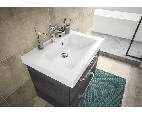 Meuble-lavabo de salle de bain avec lavabo, robinet et tiroirs devant un mur carrelé