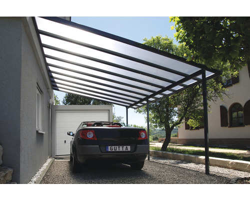 Carport mit Stahlrahmen und transparentem Dach neben einem Haus mit Garage