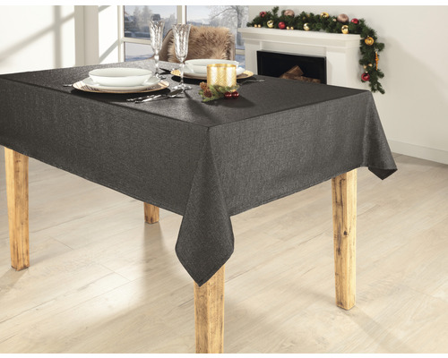 Table à manger avec nappe grise, vaisselle et décoration en arrière-plan