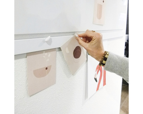 Wanddekoration mit Bildern, die mit Magneten an einer Leiste befestigt sind