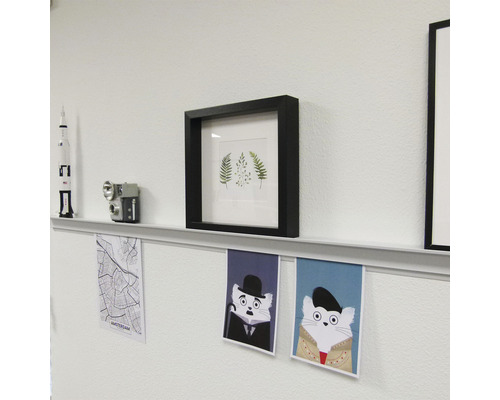 Décoration murale avec cadres, étagère et affiches