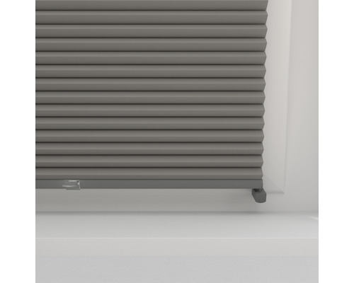 Nahaufnahme einer grauen Fensterplisseeanlage zur Lichtregulierung und Dekoration